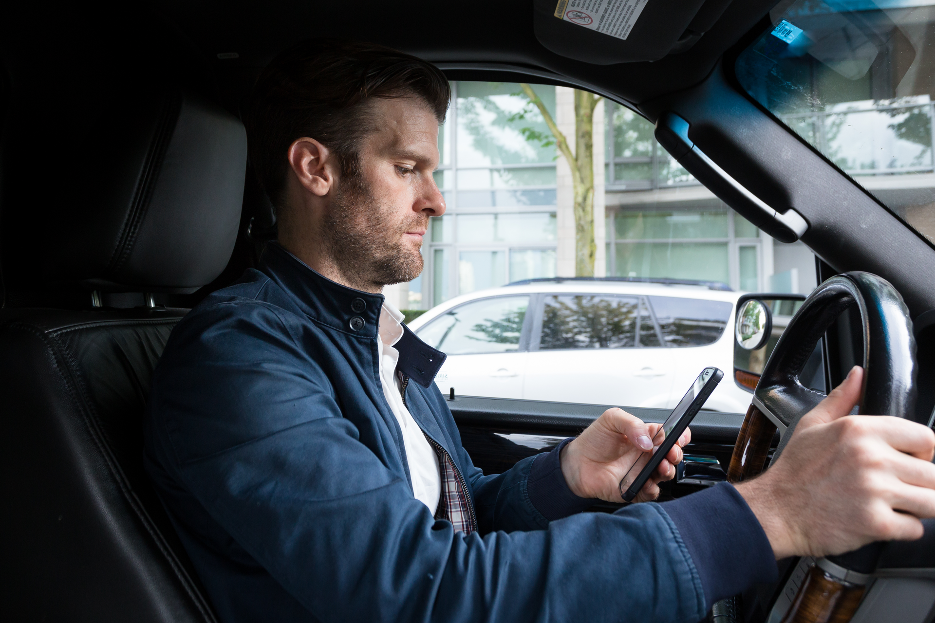 A Middle Aged Caucasian Man Distracted Driving While Using A Mobile Device 162724637 62bdce26ddd64