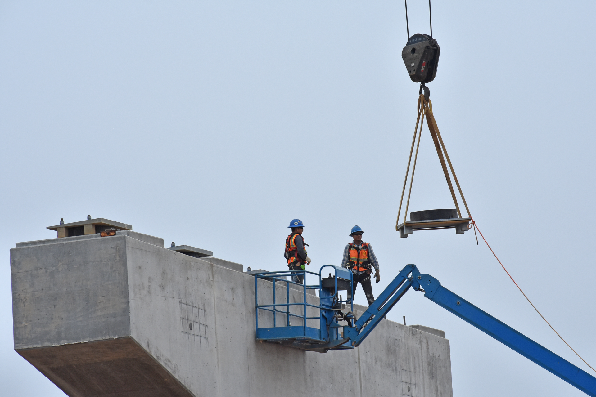 Two Bridge Construction Workers Wait On Bridge Parts Alan Stoddard 62d6ac2e0e3e4
