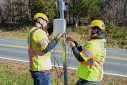 Virginia Tech Transportation Institute researchers (from left) Will Vaughn and Daniel Burdisso install part of the VTTI Smart Work Zone on a road sign. Photo by Jean Paul Talledo Vilela for Virginia Tech. Virginia Tech Transportation Institute researchers (from left) Will Vaughn and Daniel Burdisso install part of the VTTI Smart Work Zone on a road sign. Photo by Jean Paul Talledo Vilela for Virginia Tech.