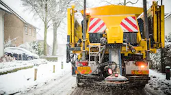 Winter road maintenance truck spreading salt and sand