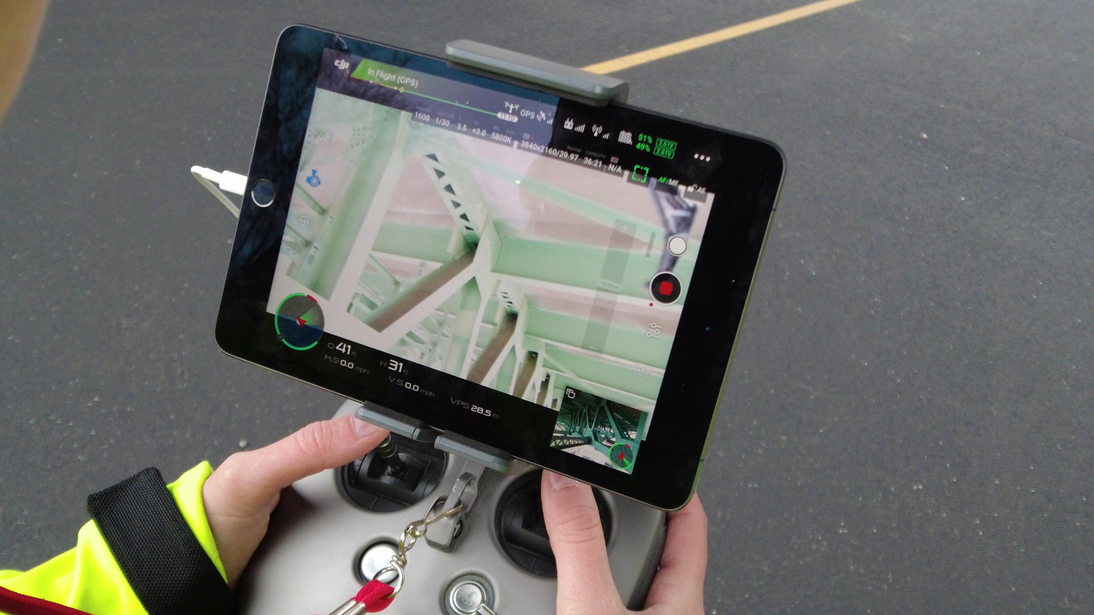 Sensor operator performing an in-flight inspection of a deck truss.