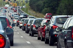 Vehicles lined up in a traffic jam during on a three-lane highway during rush hour. Vehicles lined up in a traffic jam during on a three-lane highway during rush hour.