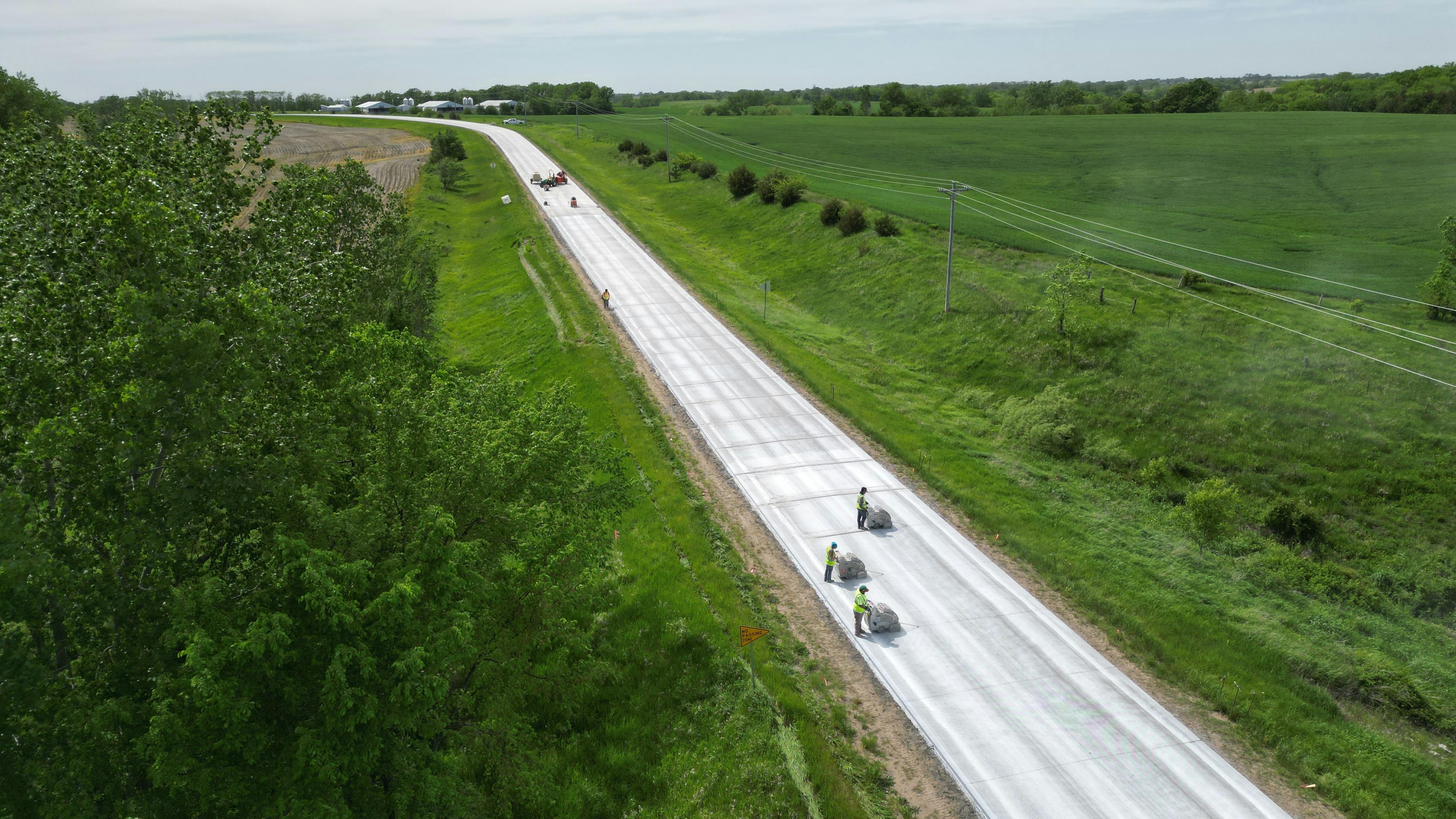 An aerial photo of crews completing a concrete overlay on a roadway in Iowa.