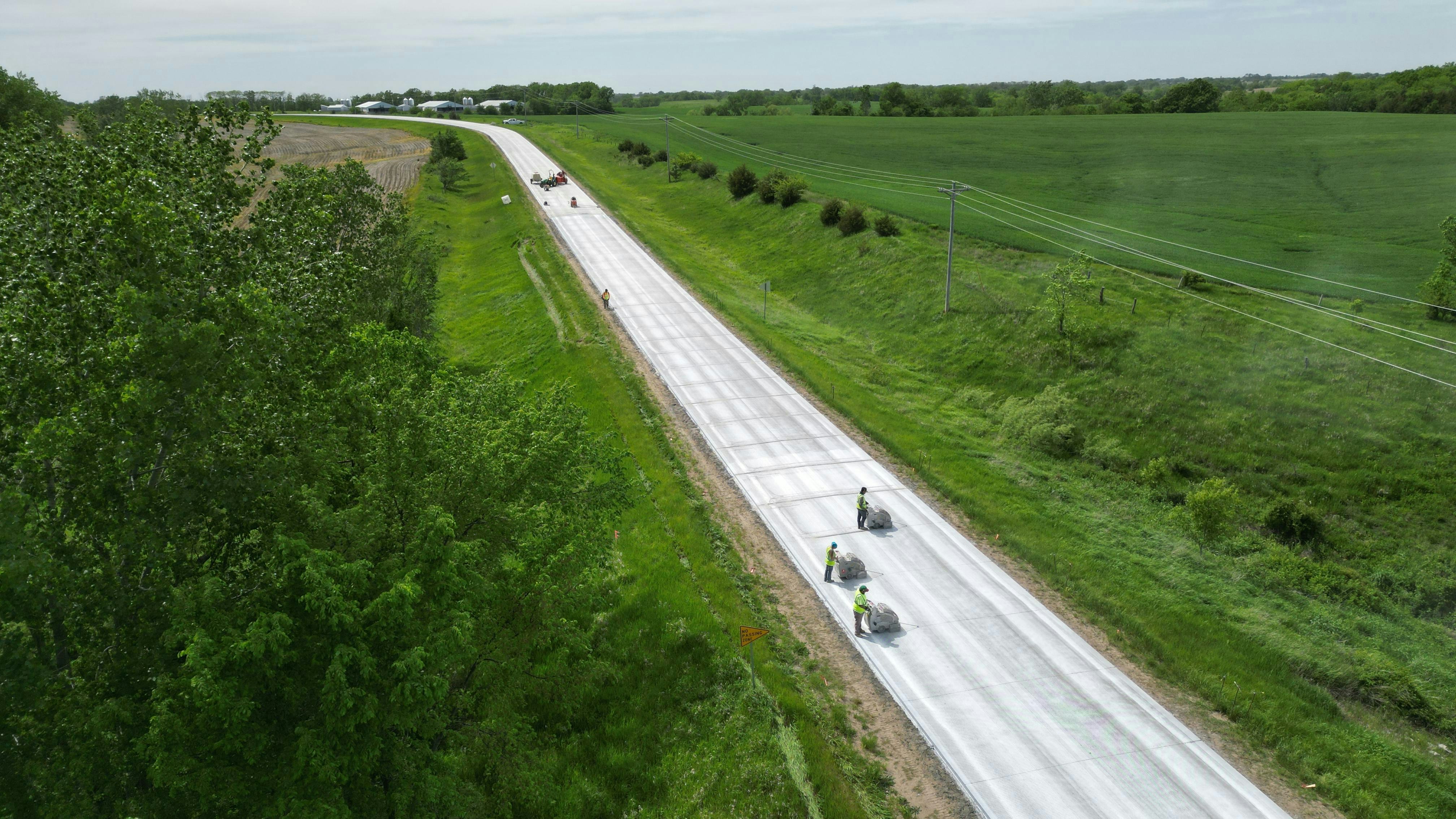 An aerial photo of crews completing a concrete overlay on a roadway in Iowa.