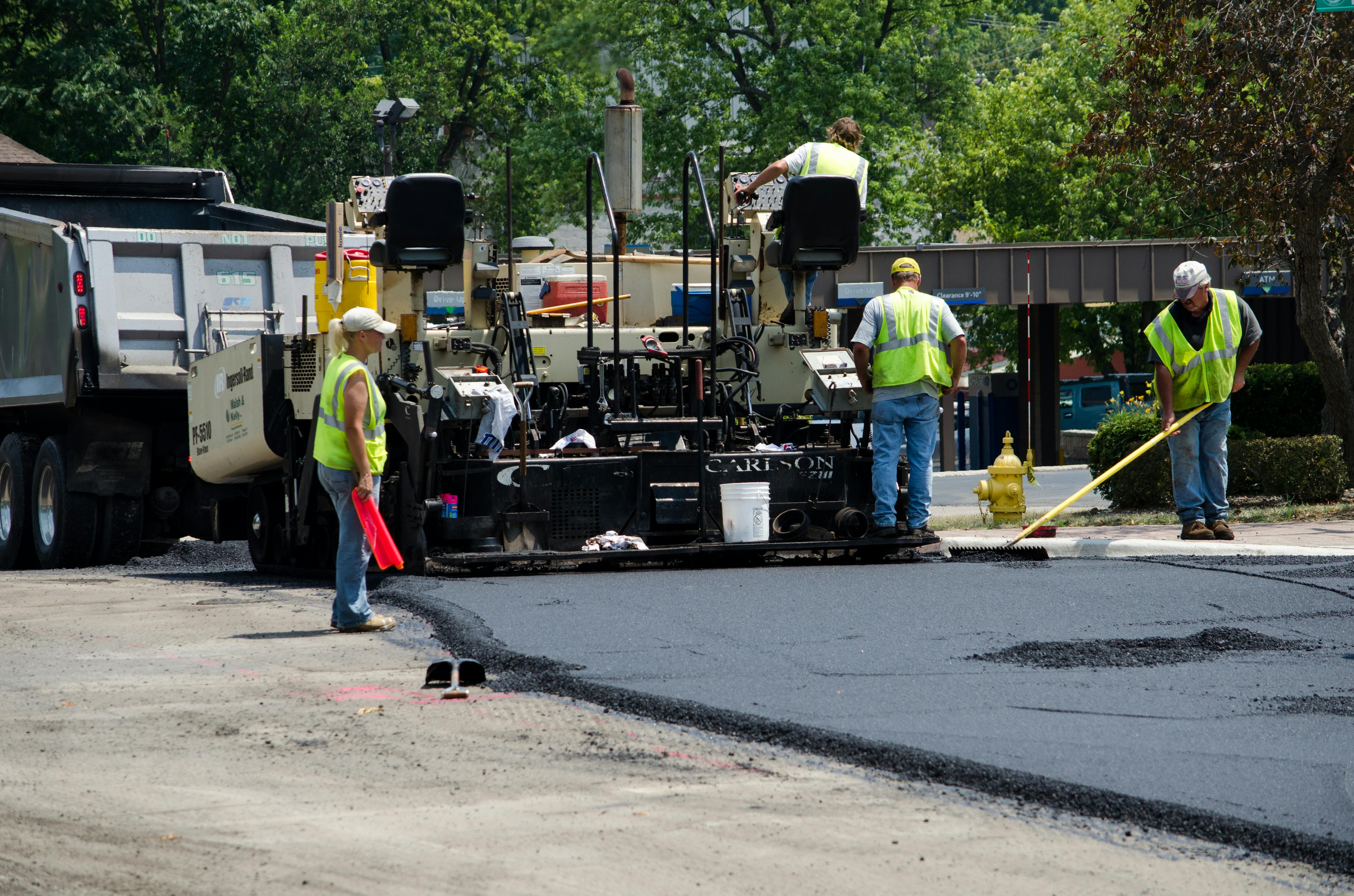 Workers completing repaving work on a roadway.