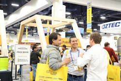 Three attendees of World of Concrete talking on the trade show floor. Three attendees of World of Concrete talking on the trade show floor.