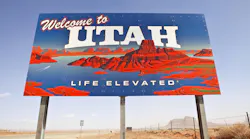 A Welcome to Utah sign displayed in a desert landscape.