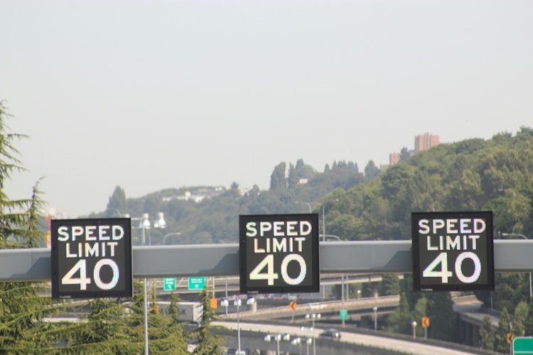 Electronic speed limit signs displaying a 40 mile per hour speed limit installed overhead on a highway.