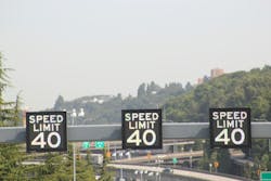Electronic speed limit signs displaying a 40 mile per hour speed limit installed overhead on a highway. Electronic speed limit signs displaying a 40 mile per hour speed limit installed overhead on a highway.