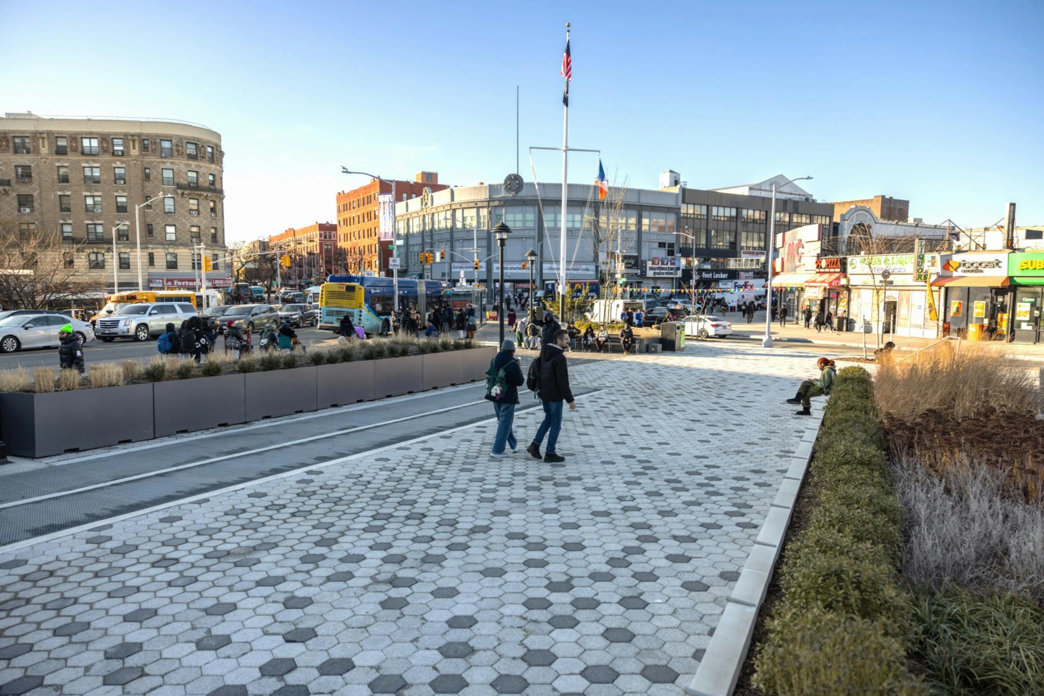 Pedestrians walking on the sidewalk at the revamped Monsignor Raul Del Valle Square in Hunts Point, Bronx