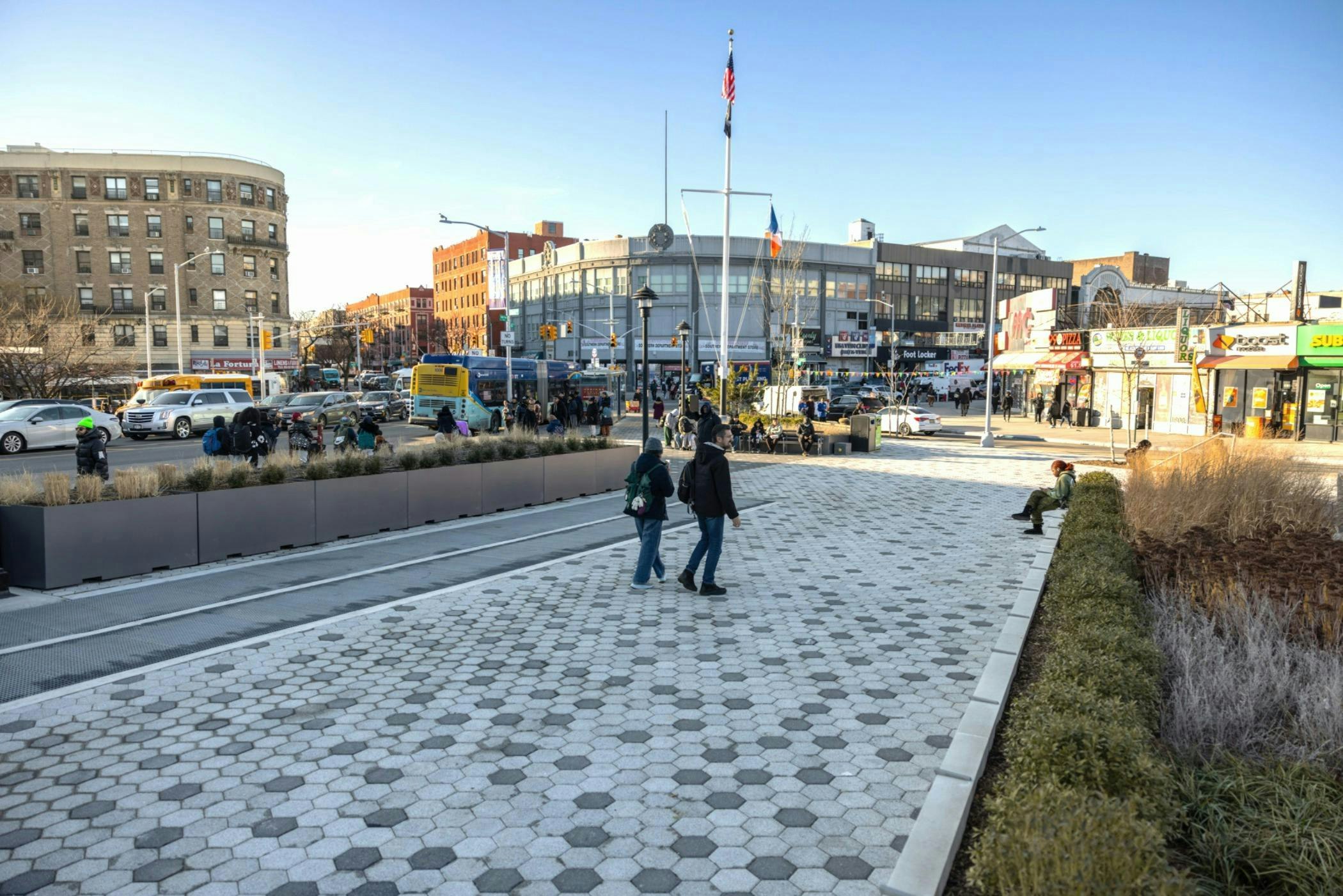 Pedestrians walking on the sidewalk at the revamped Monsignor Raul Del Valle Square in Hunts Point, Bronx