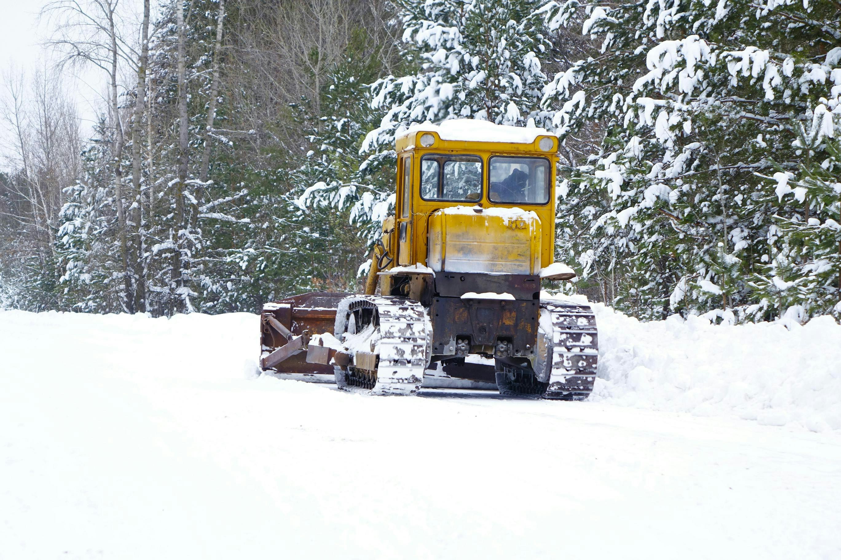 A road grader being used for snow and ice removal