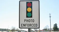 A photo enforced sign displaying a traffic light.