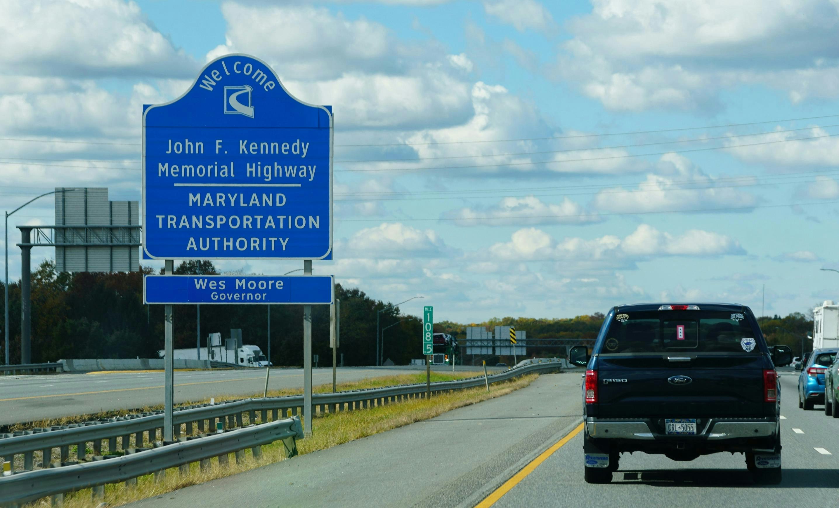 A sign on the side of a highway in Maryland welcoming drivers to the John F. Kennedy Memorial Highway.