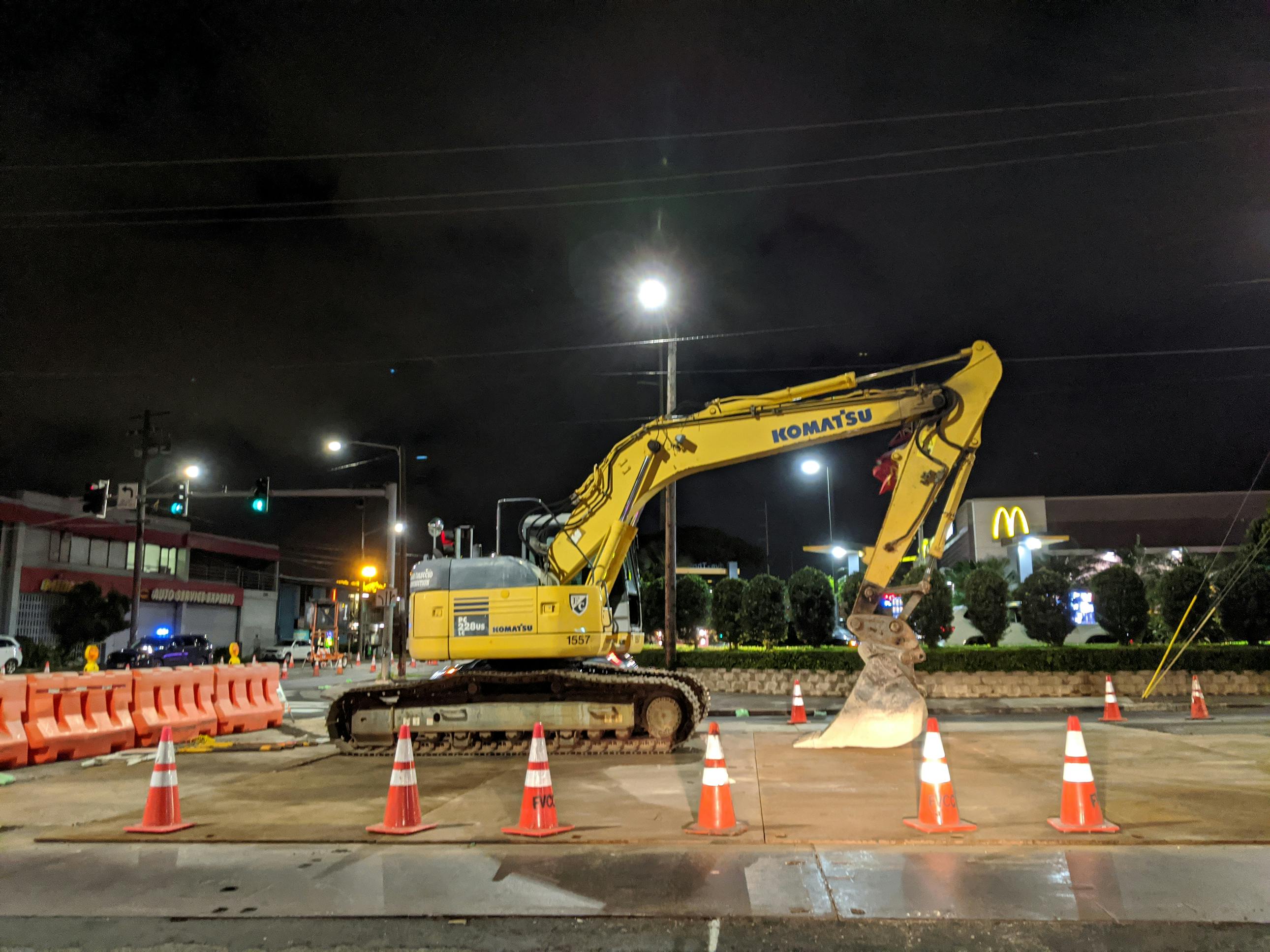An excavator conducting road work at night.