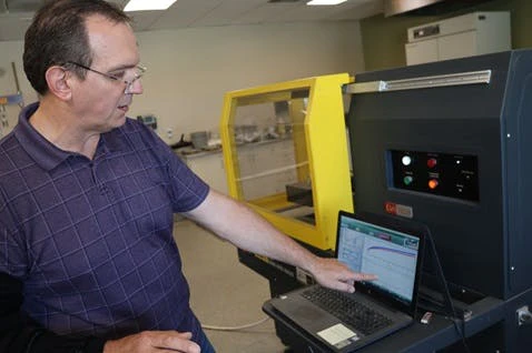 Brian Paroda pointing at a laptop displaying test results.