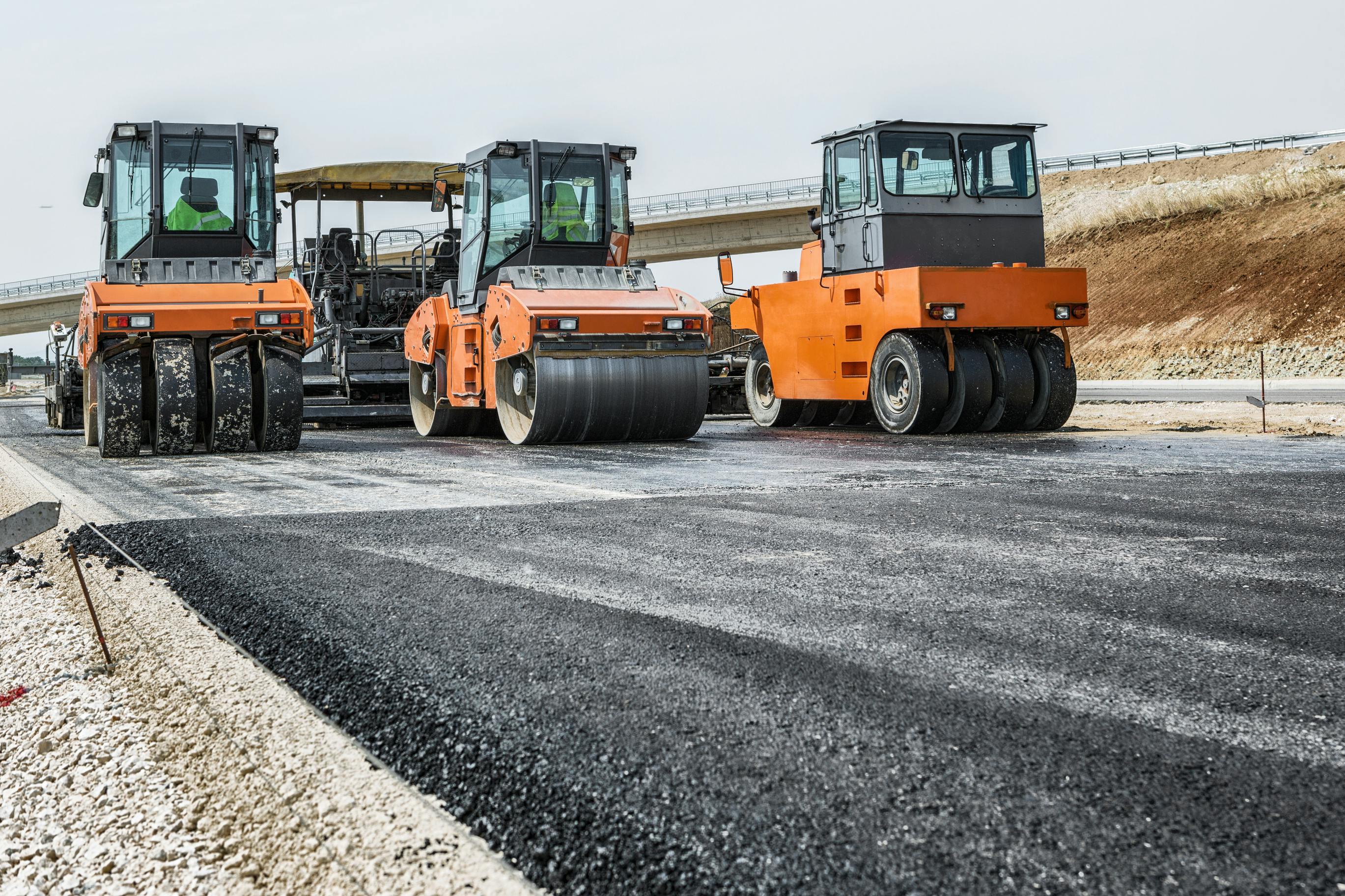 Road pavers driving along a roadway during a construction project.
