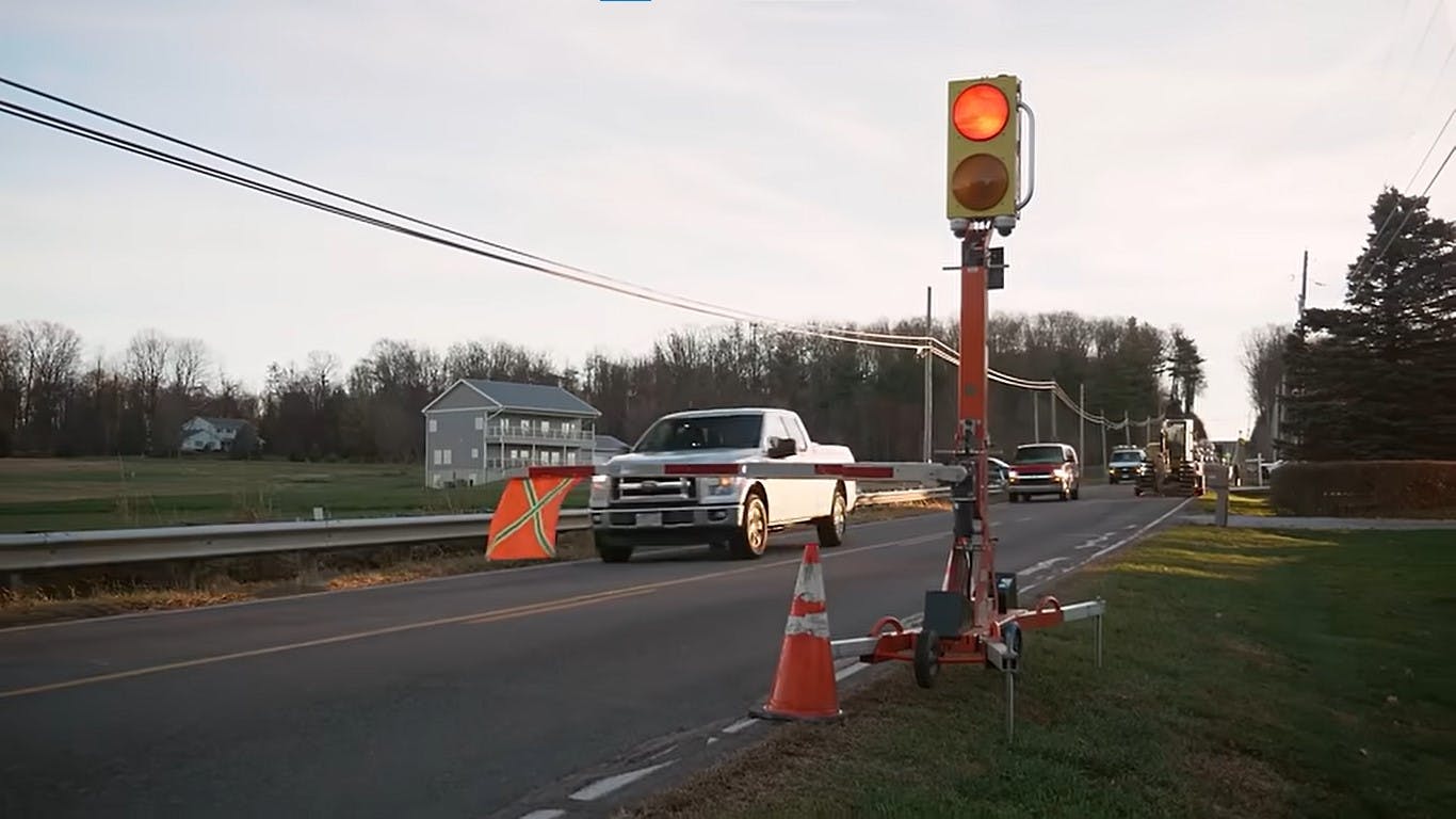Connected work zone equipment on the side of a roadway blocking traffic on one side.