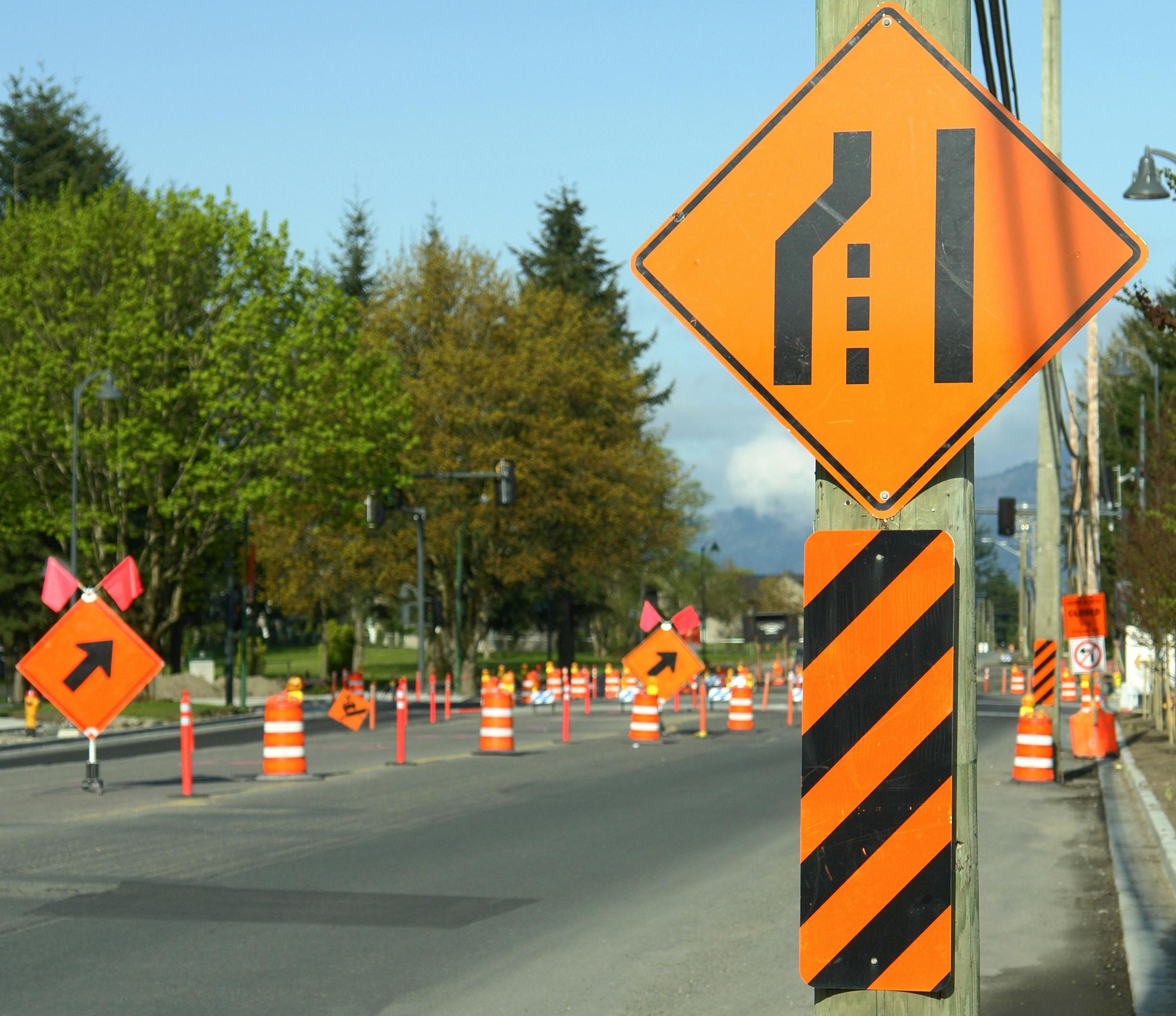 Signs directing drivers to merge through a work zone.