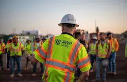 A road worker wearing his safety vest with the back reading 'AWP Safety.' A road worker wearing his safety vest with the back reading 'AWP Safety.'