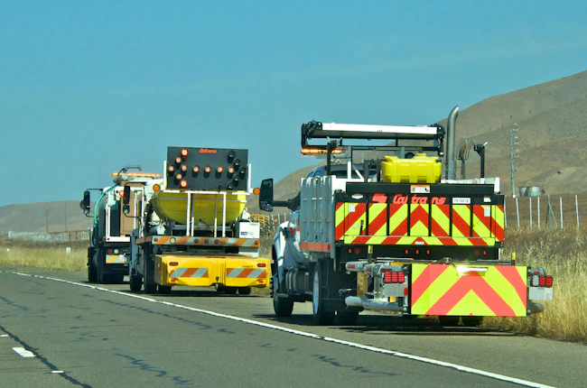 A TMA traveling in the shoulder of a highway during road work.
