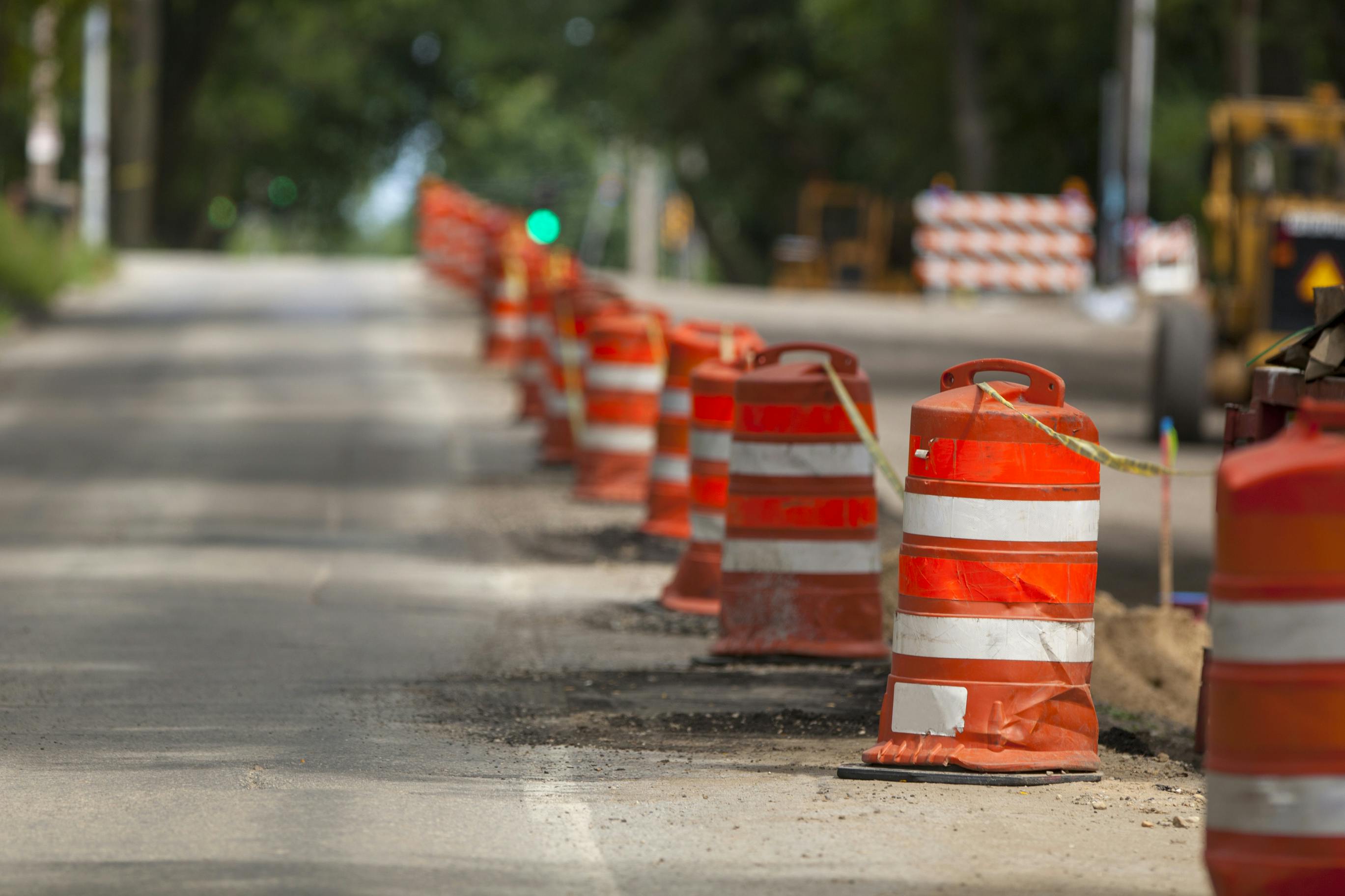 Safety barrels lining a work zone along a roadway.