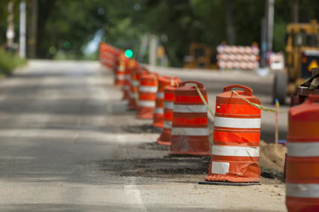 Safety barrels lining a work zone along a roadway.