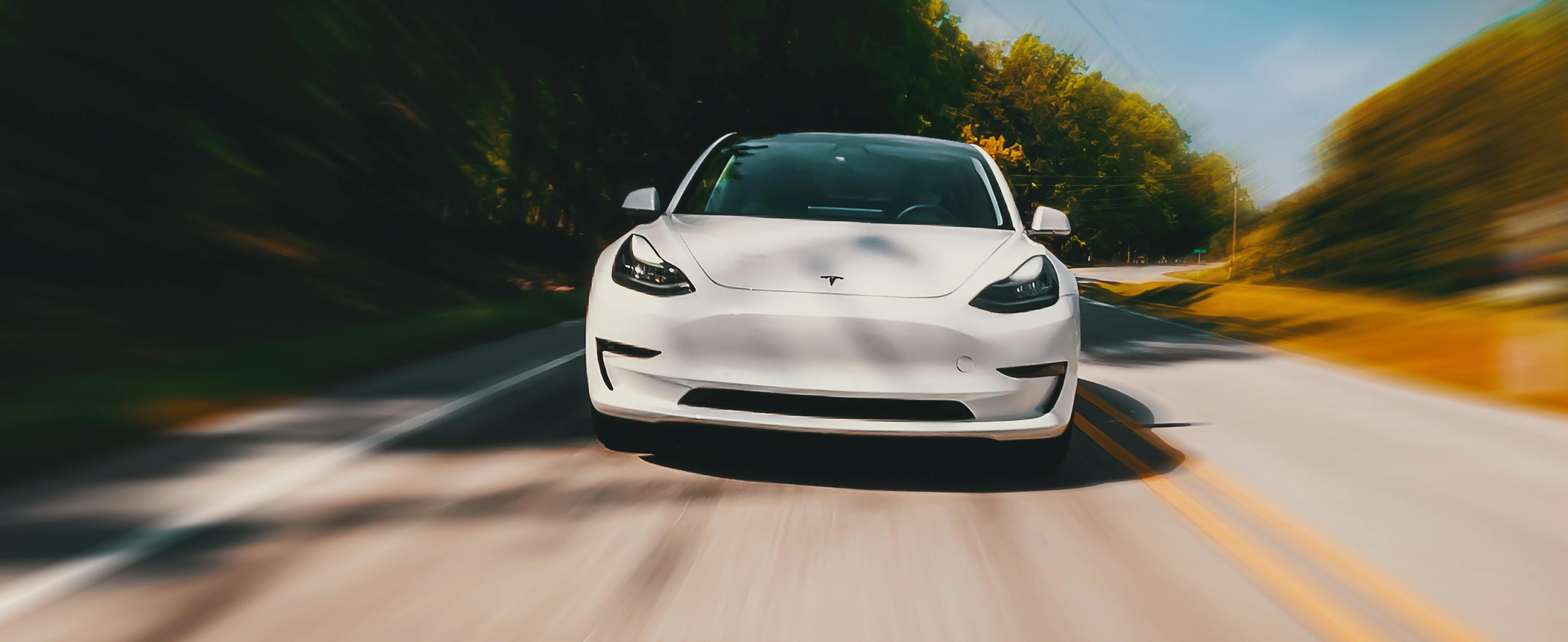 A Tesla zooming down a roadway.