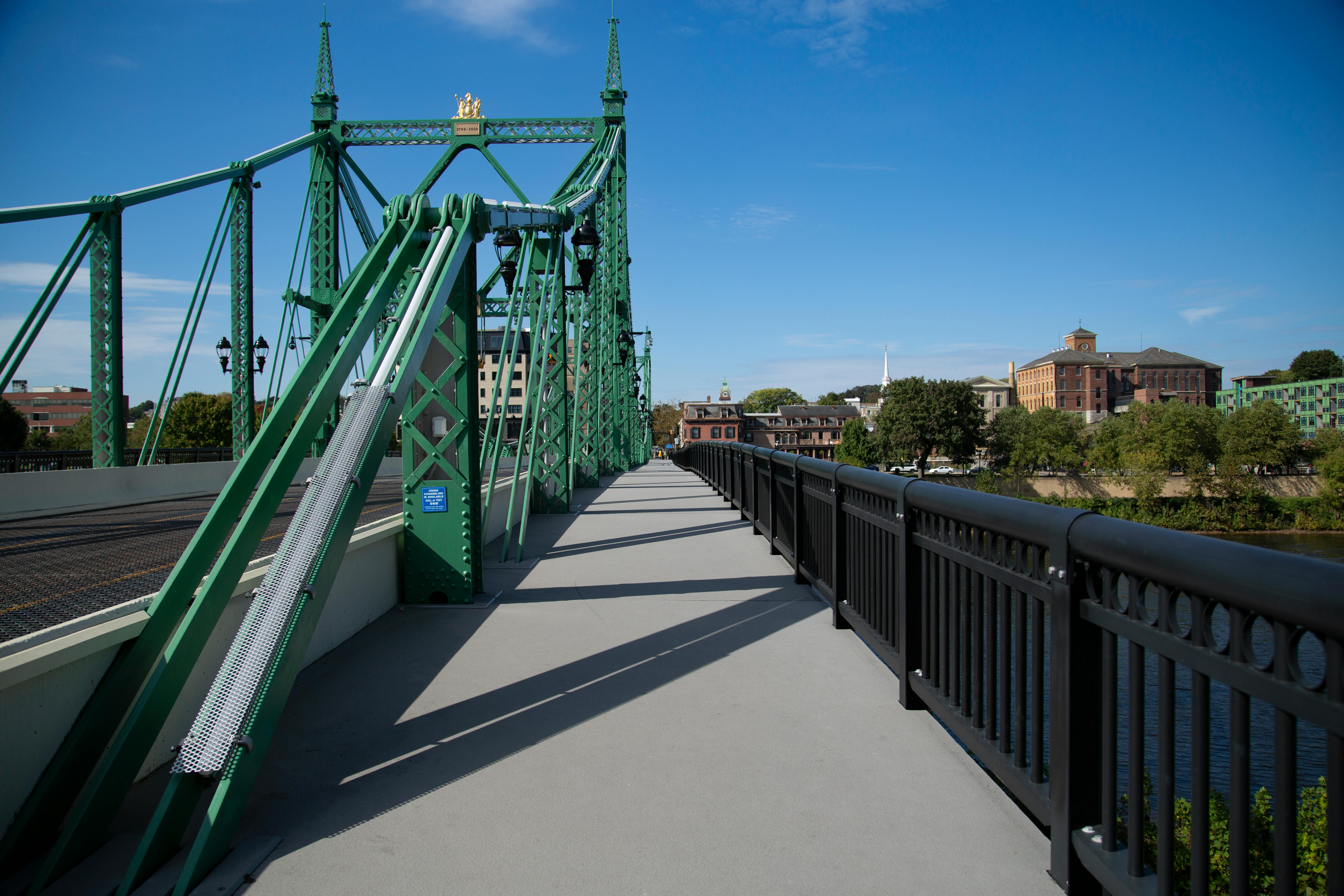 A cantilever sidewalk running parallel to a vehicle bridge.