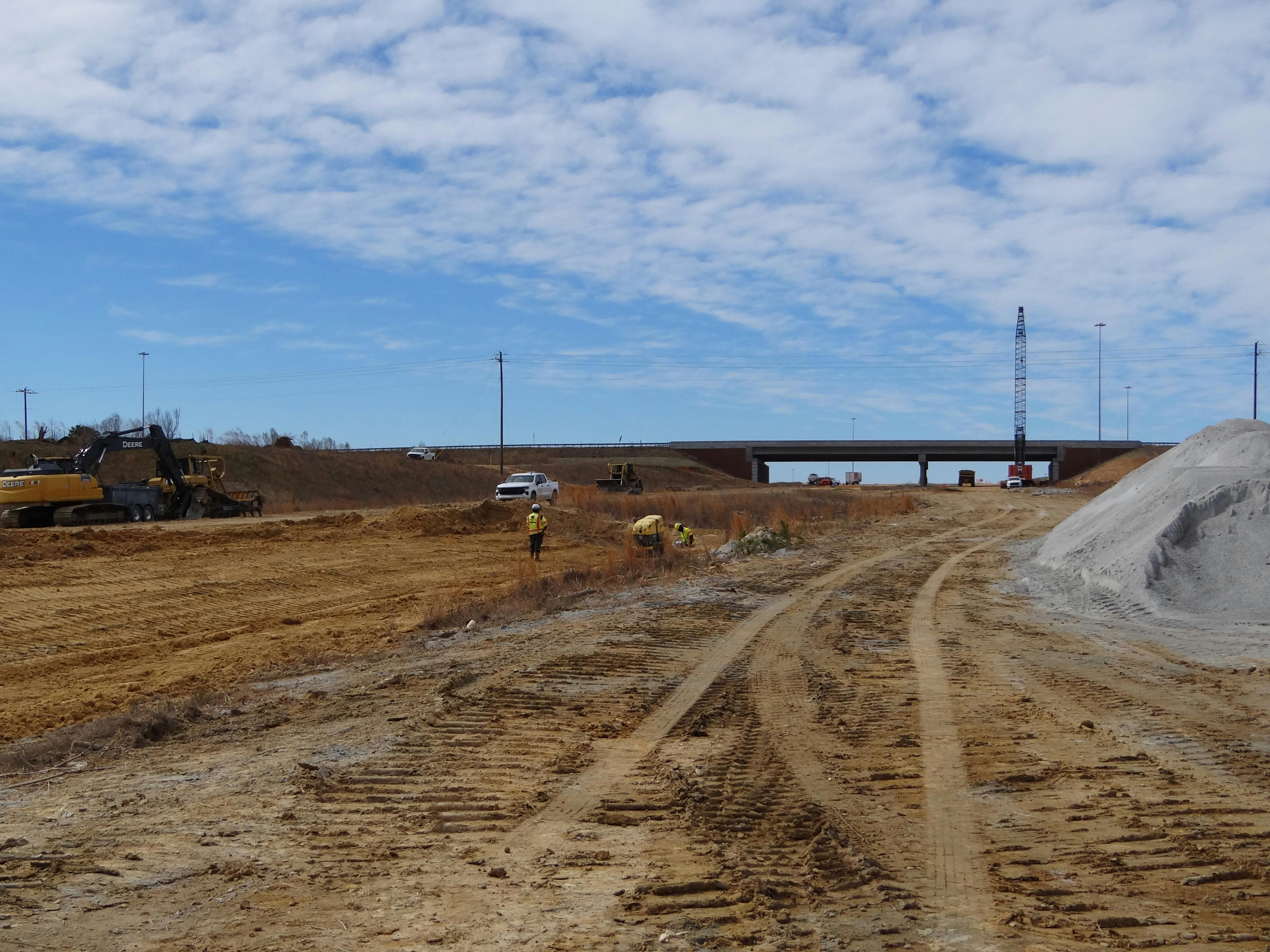 Workers clearing out a dirt path for the future Interstate 540 Outer Loop.