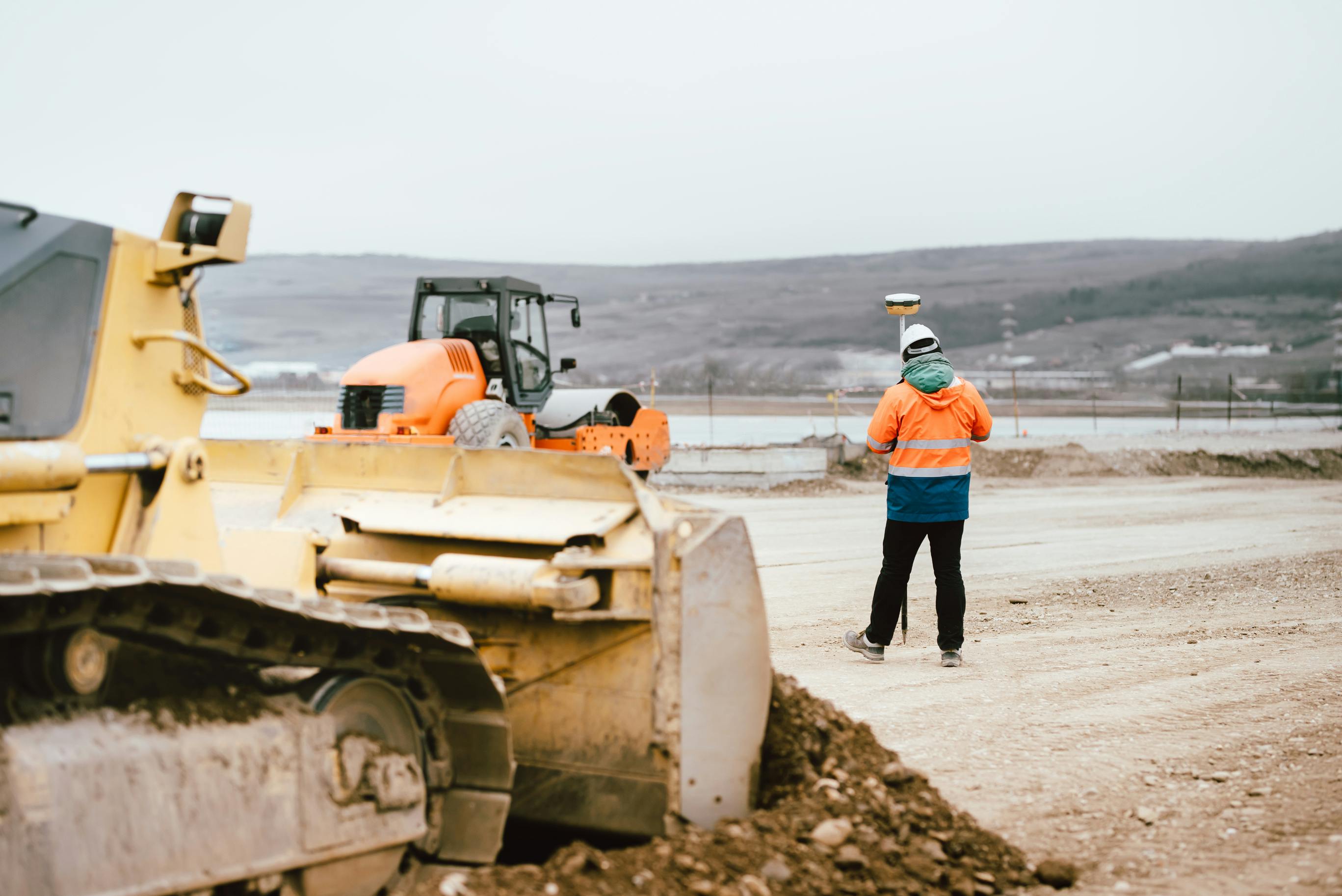 Engineer with GPS system at roadway construction site