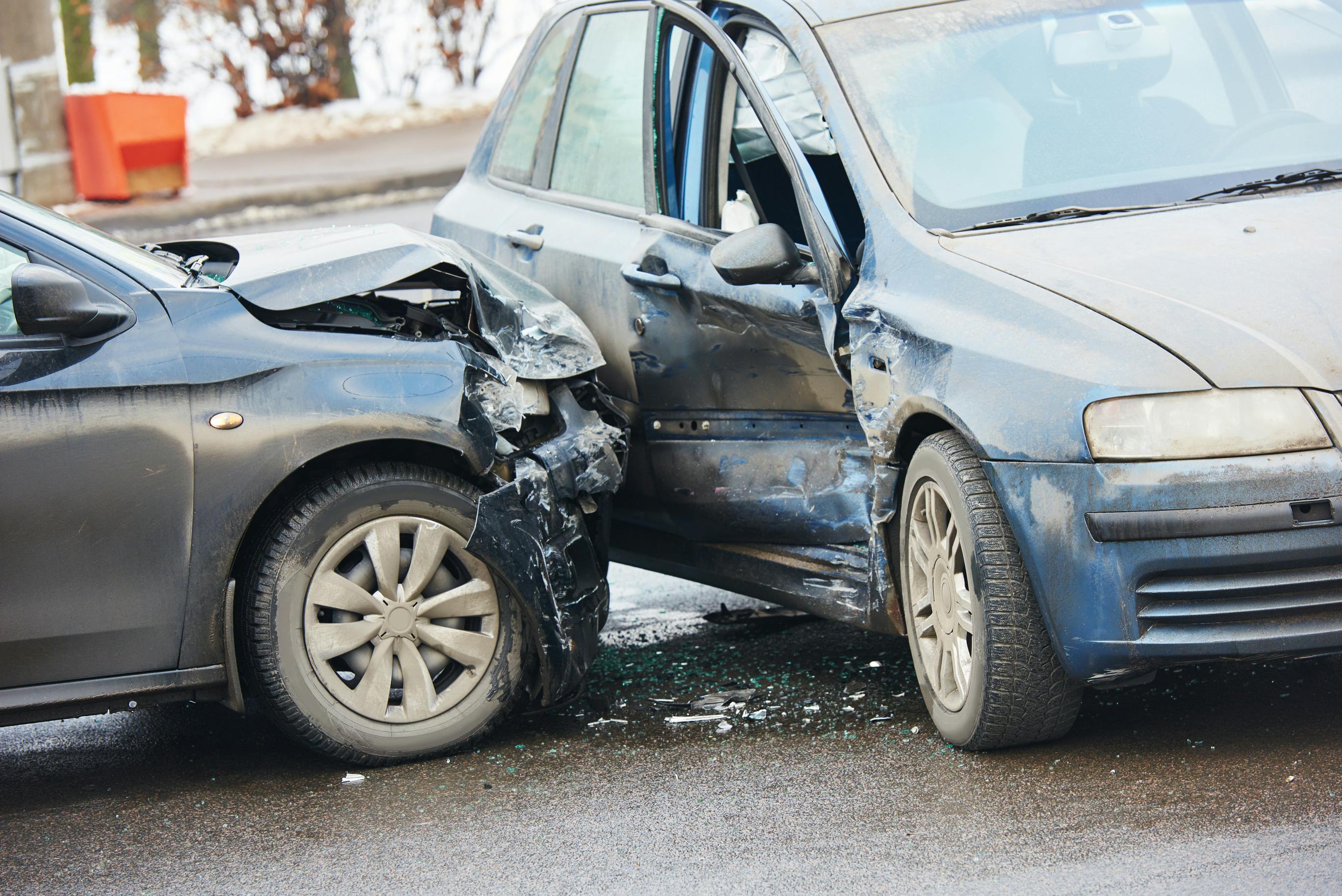 Two cars following a crash along a roadway.