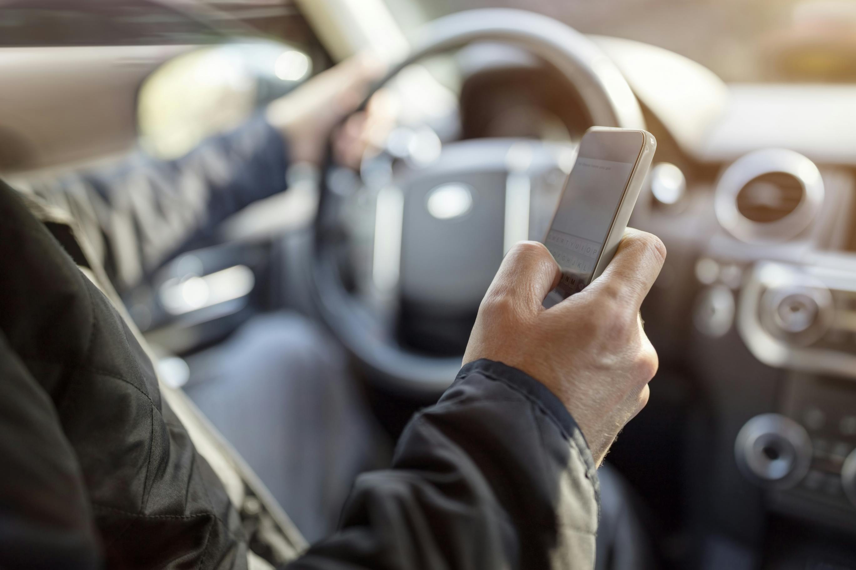 A driver looking at their phone while operating a vehicle.