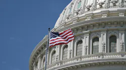 The U.S. Capitol building with a flag waving in the foreground.