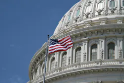The U.S. Capitol building with a flag waving in the foreground. The U.S. Capitol building with a flag waving in the foreground.