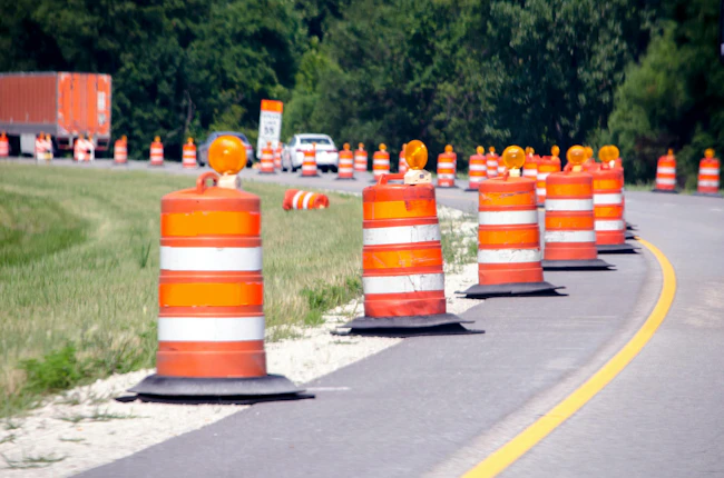 A highway work zone with a barrier of barrels.