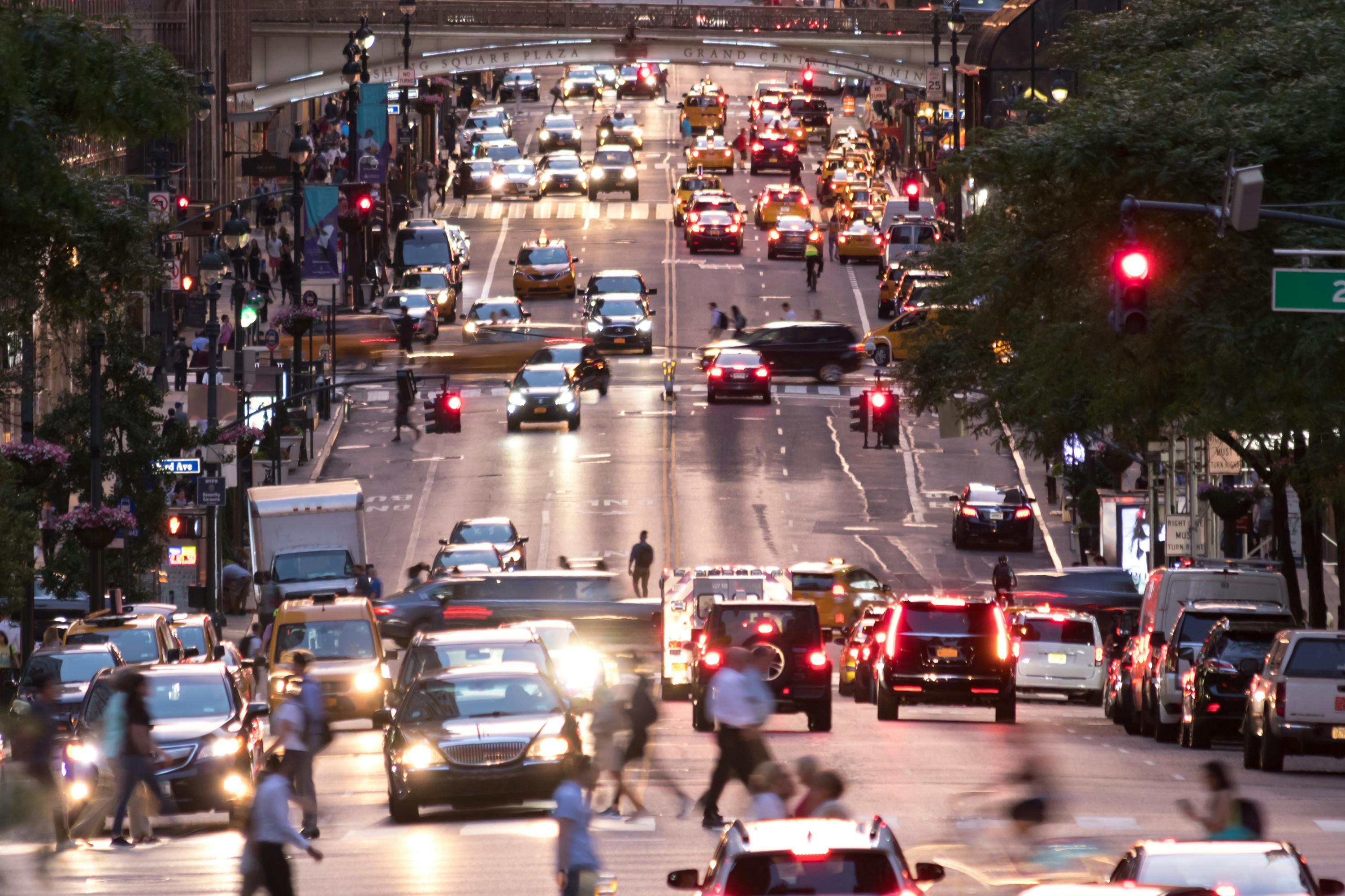 Busy evening cityscape with cars and people on 42nd Street in New York City.