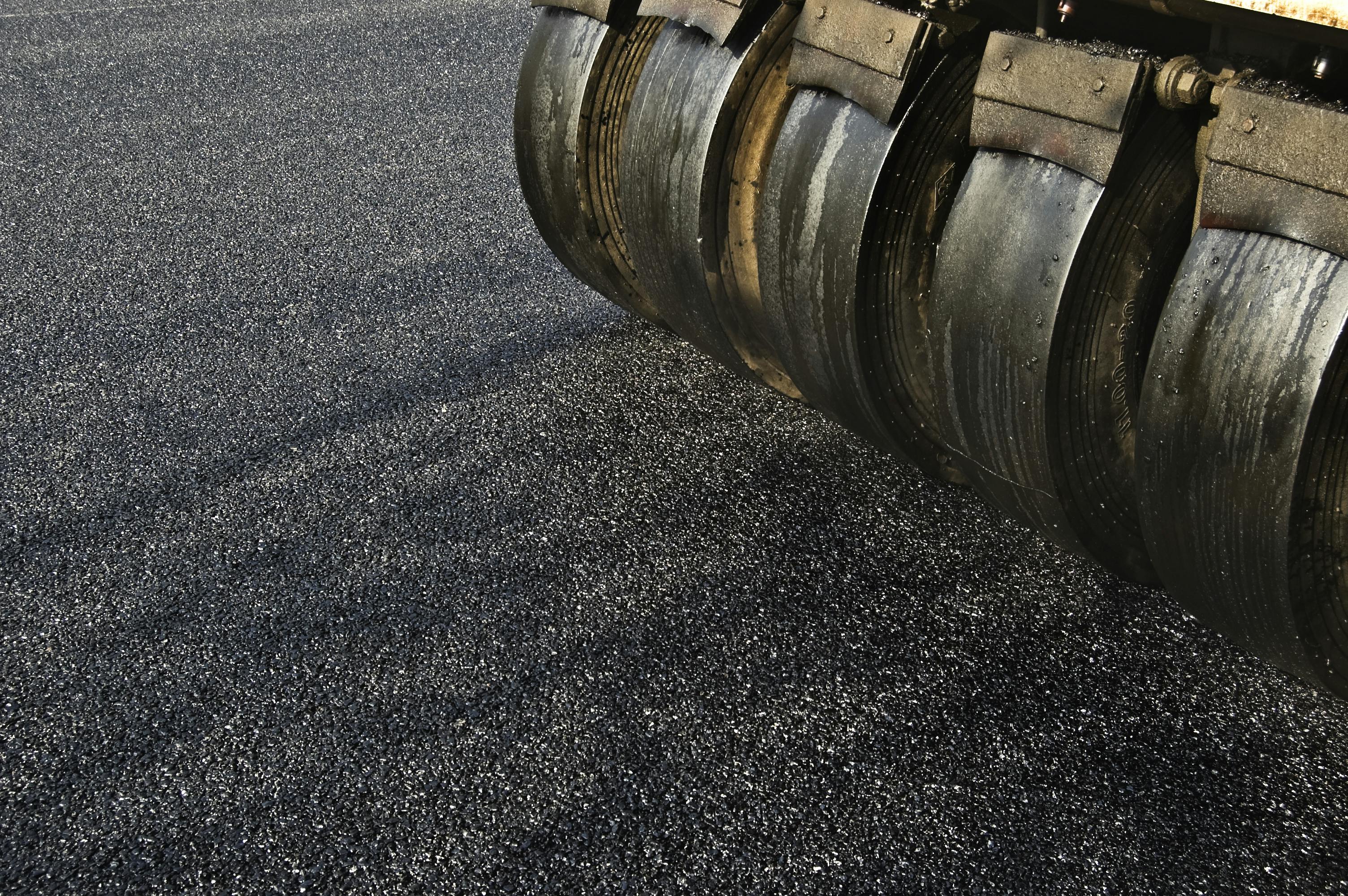 A paver placing asphalt on a roadway.