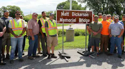 Iowa DOT District 4 staff and Matt Dickerson’s coworkers gather around the newly unveiled Matt Dickerson Memorial Bridge sign during the dedication ceremony in Neola on June 11.