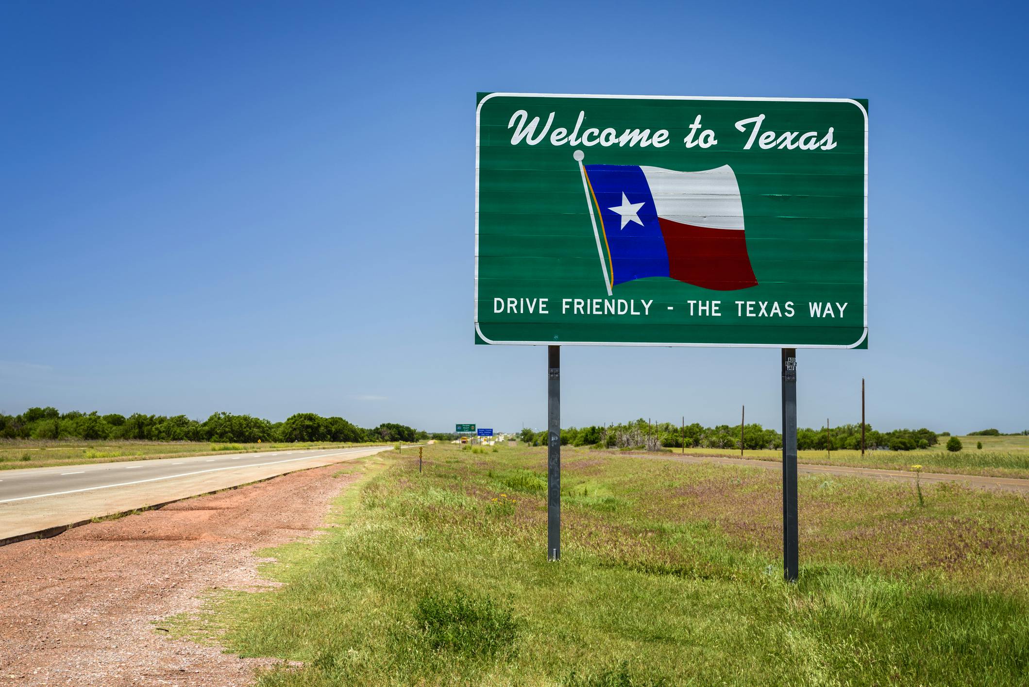 A Welcome to Texas sign along the roadway.