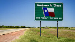 A Welcome to Texas sign along the roadway.