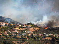 The Palisades wildfire seen burning on a hillside in 2025.
