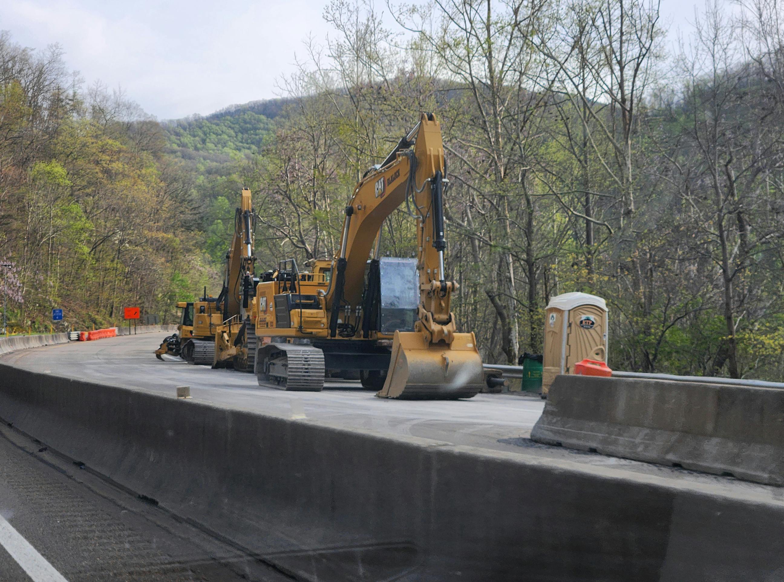 Heavy construction equipment works along Interstate 40 as crews continue rebuilding critical highway infrastructure damaged by Hurricane Helene in North Carolina and Tennessee.