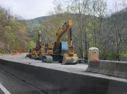 Heavy construction equipment works along Interstate 40 as crews continue rebuilding critical highway infrastructure damaged by Hurricane Helene in North Carolina and Tennessee.