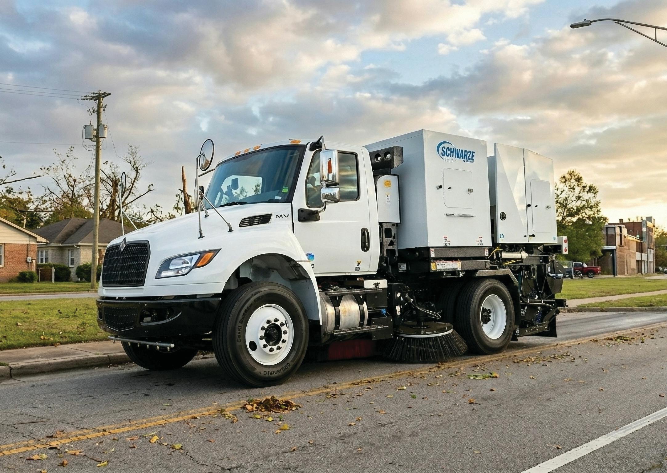 A street sweeper being used along a roadway.
