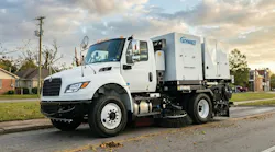 A street sweeper being used along a roadway.