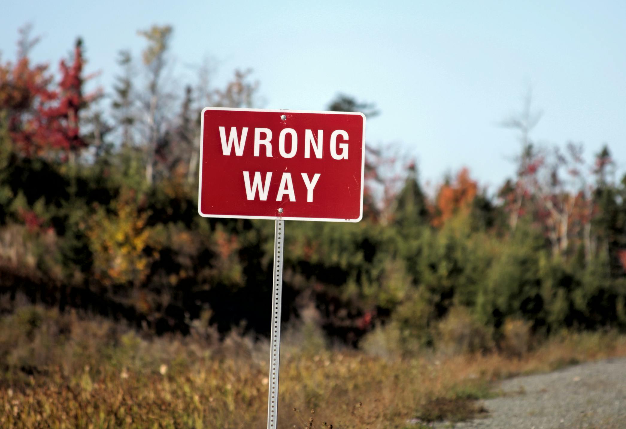 A wrong-way sign along a roadway.