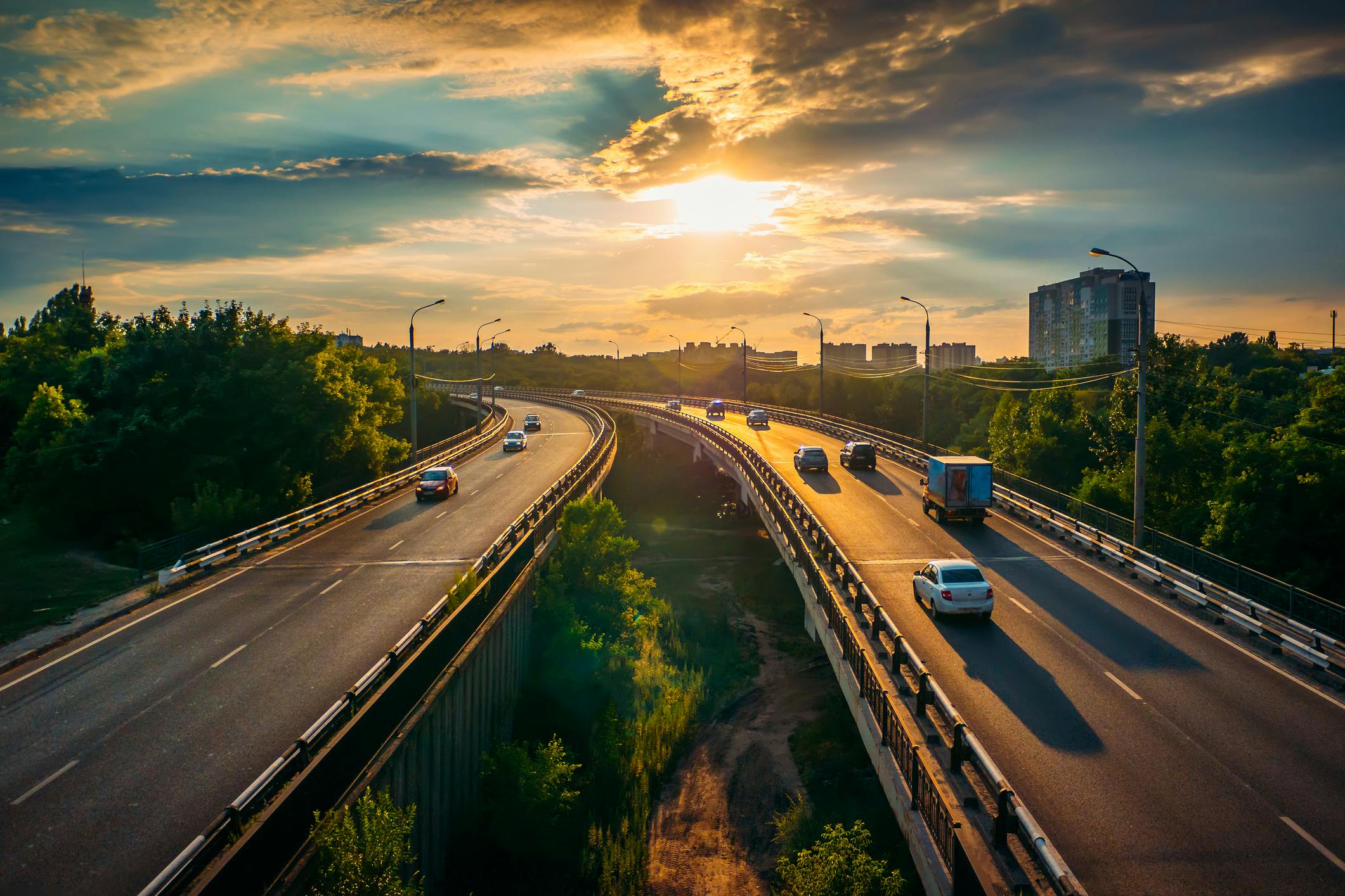 An urban highway going through a city during sunset.