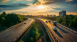 An urban highway going through a city during sunset.