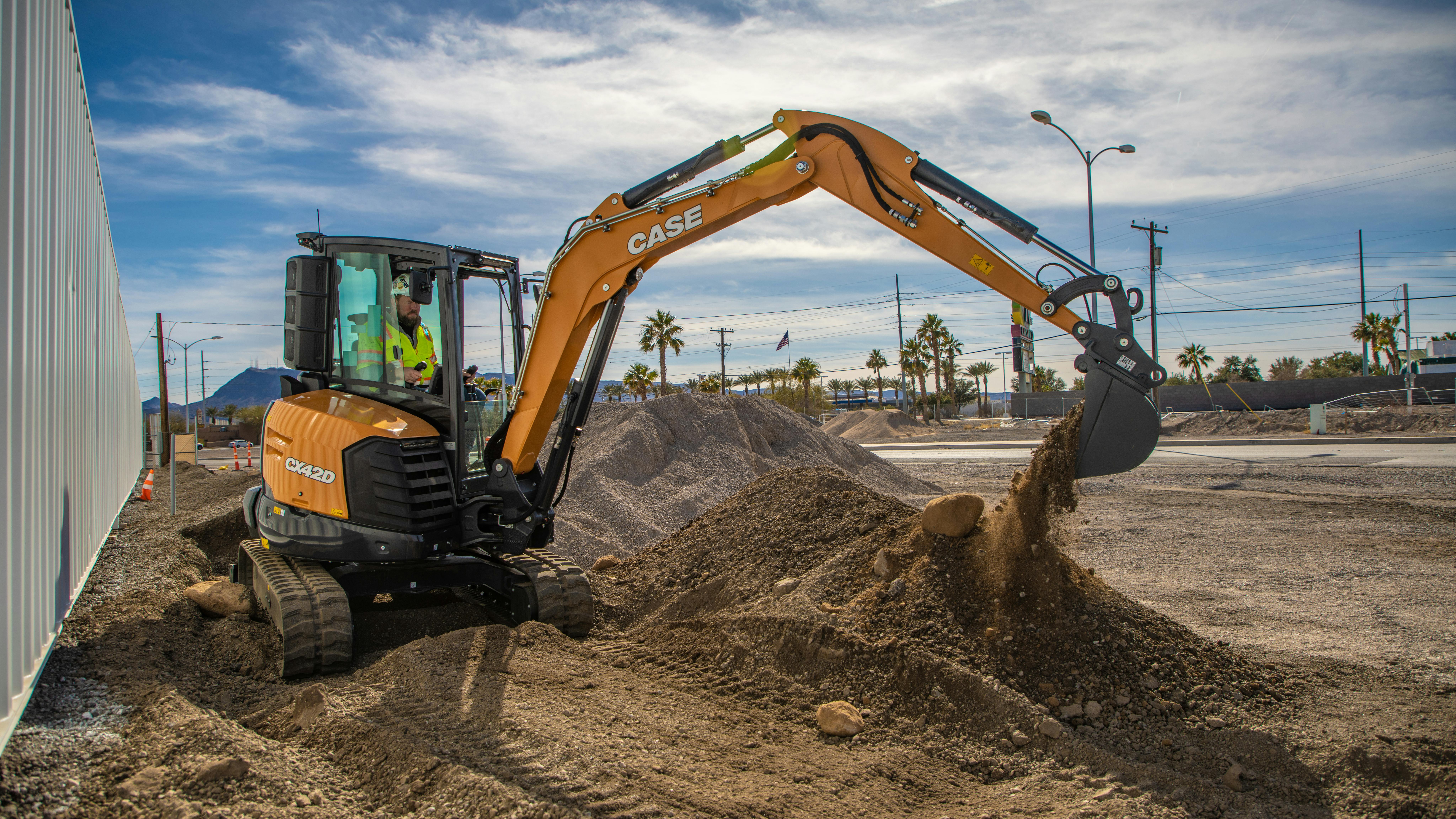 An operator using a CASE mini excavator on a job site.